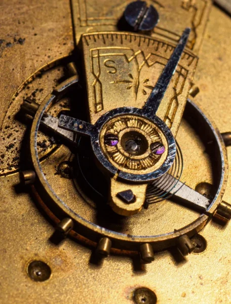 Macro detail of a brass movement's balance wheel and regulator