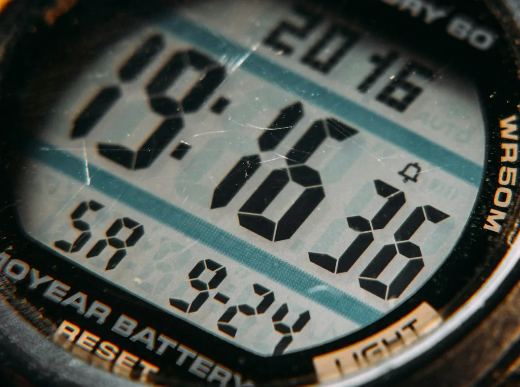Macro detail of a digital watch display showing the time and date