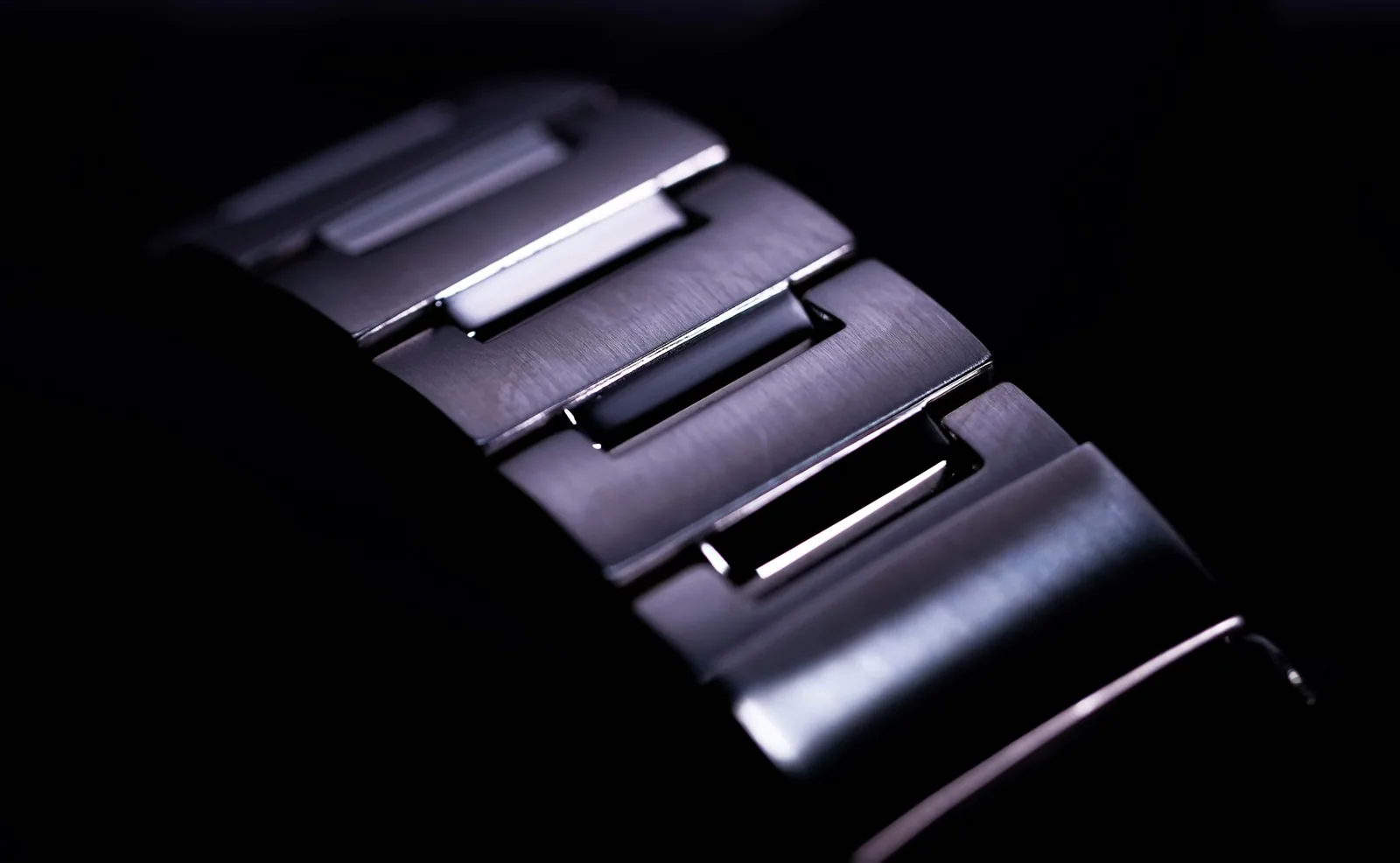 A brushed steel watch bracelet folded open to show the clasp and the individual links