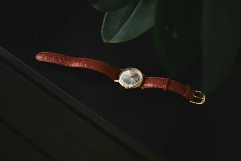 A slim watch on a leather strap seen from above