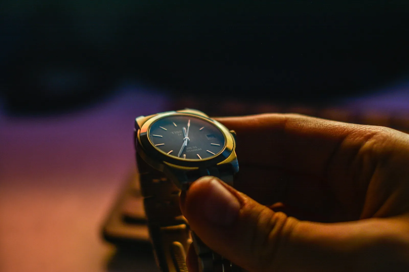 A wristwatch held in the hand, ready to be wound