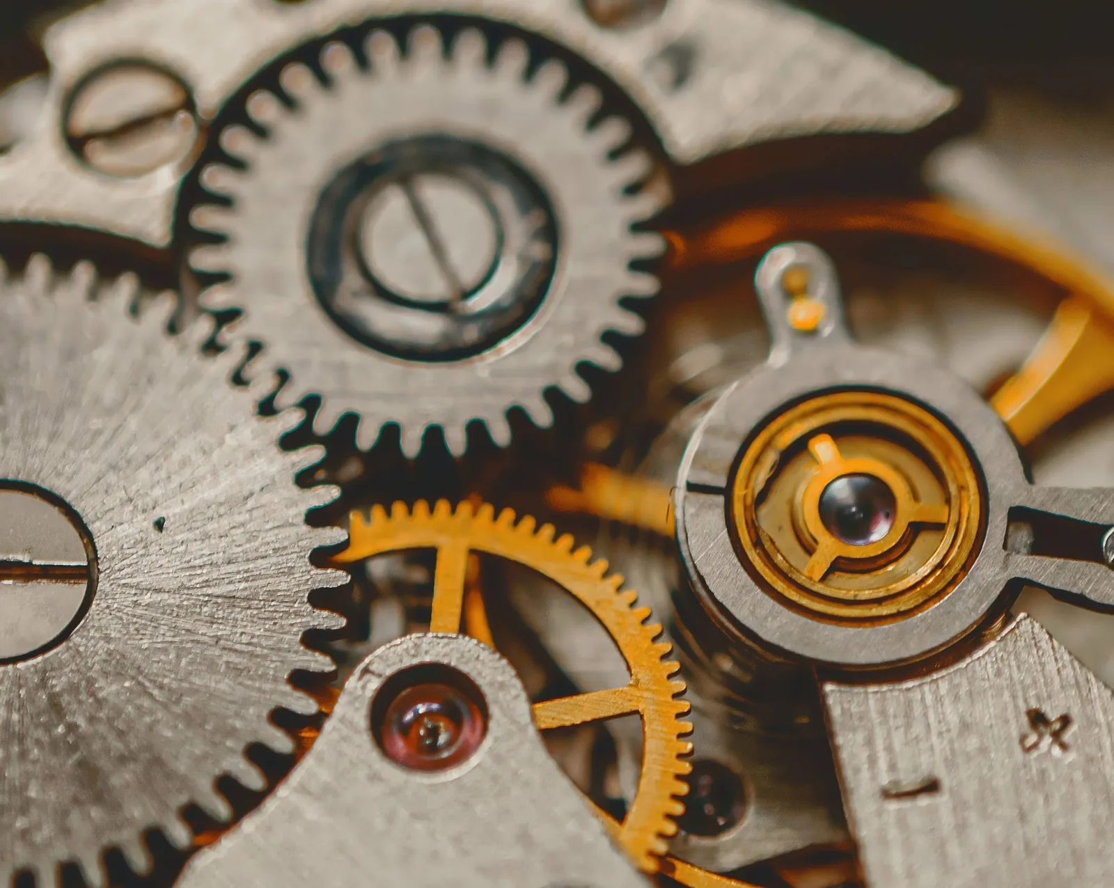 The wheels and jewelled bearings of a watch escapement seen at high magnification