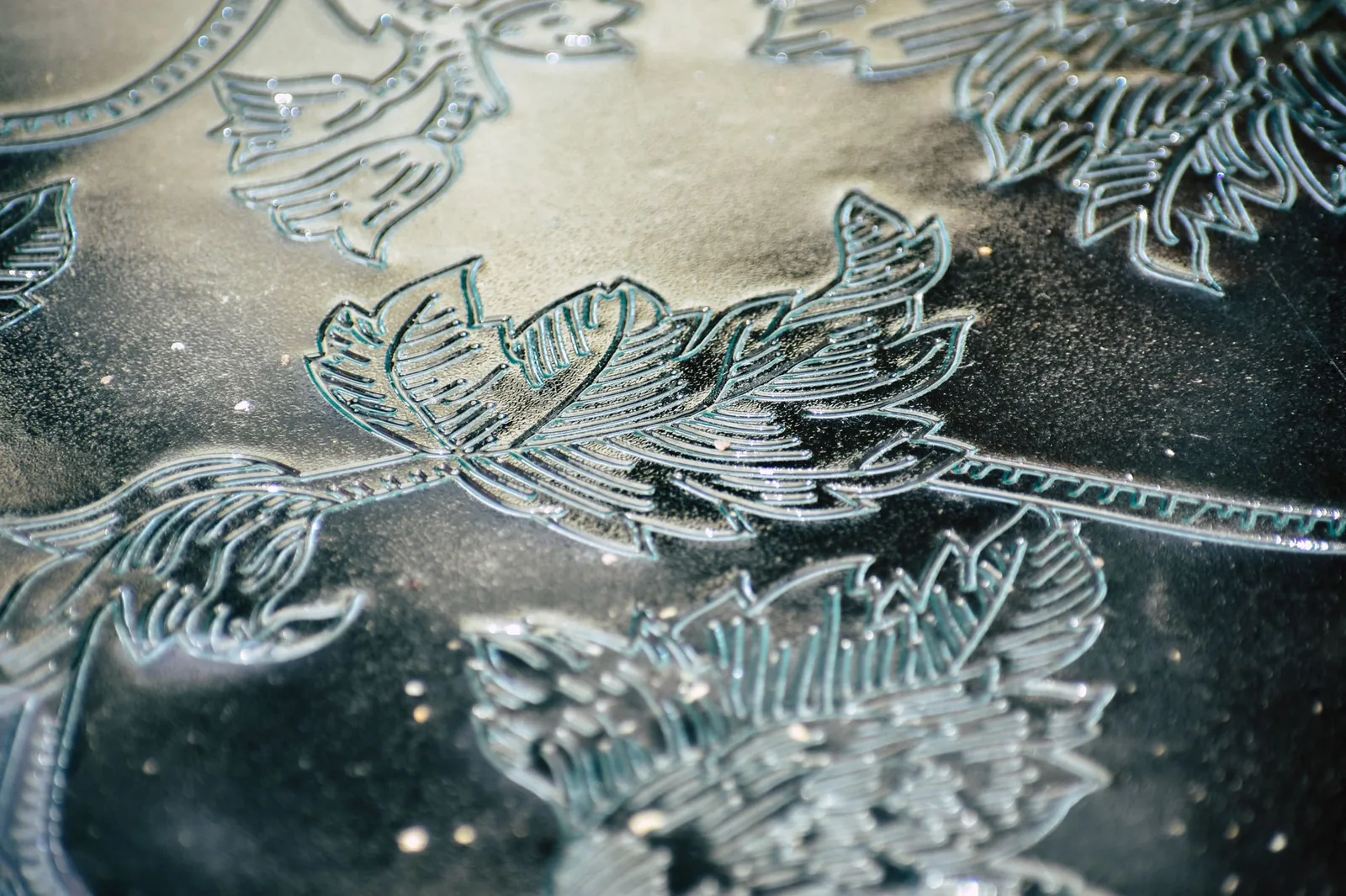 A leaf pattern engraved into a metal surface