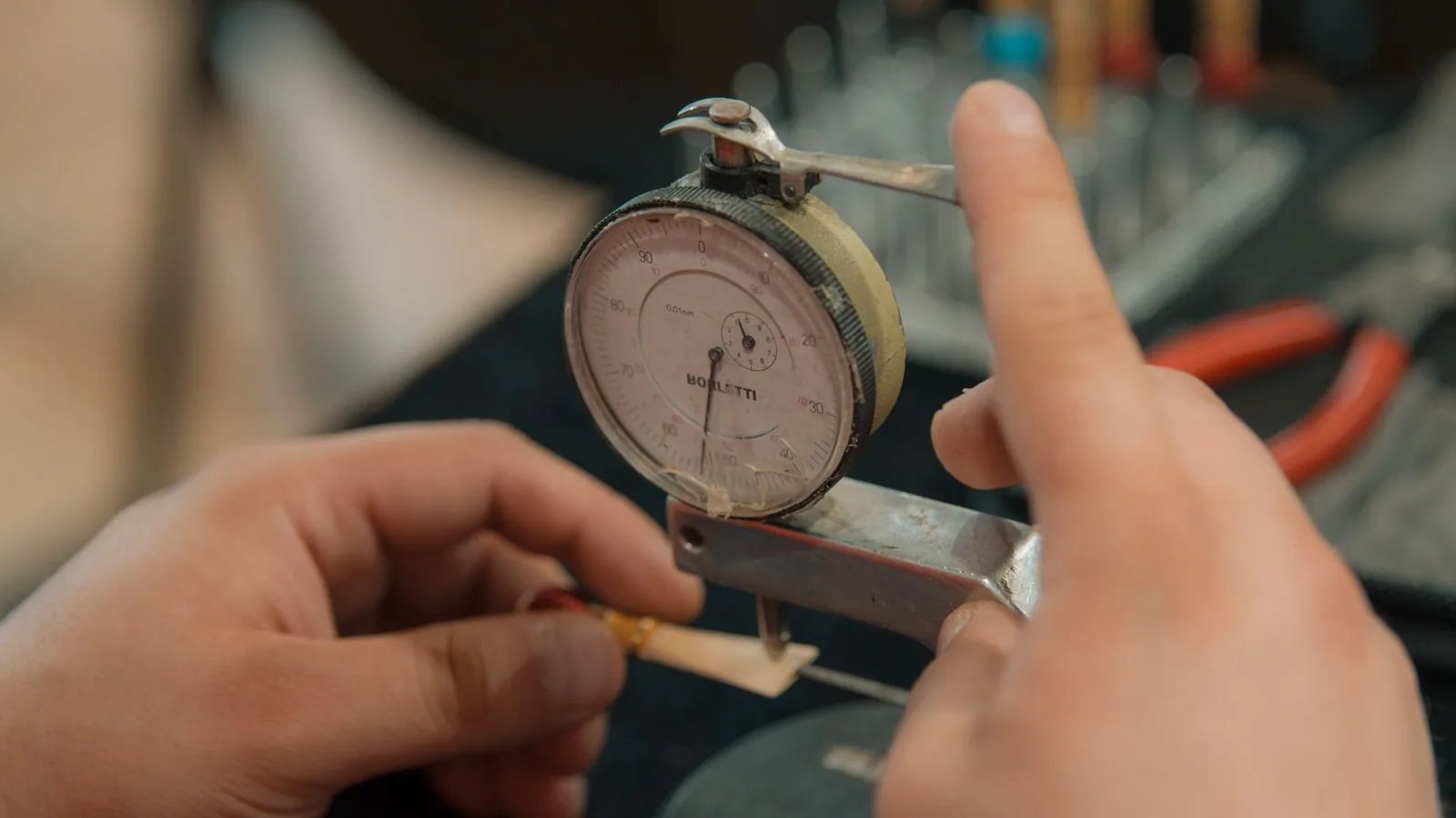 A dial gauge being read by hand