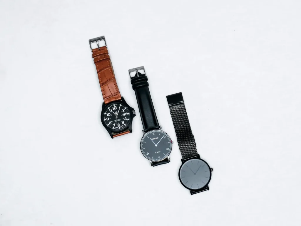 Several wristwatches of different styles arranged on a plain surface, seen from above
