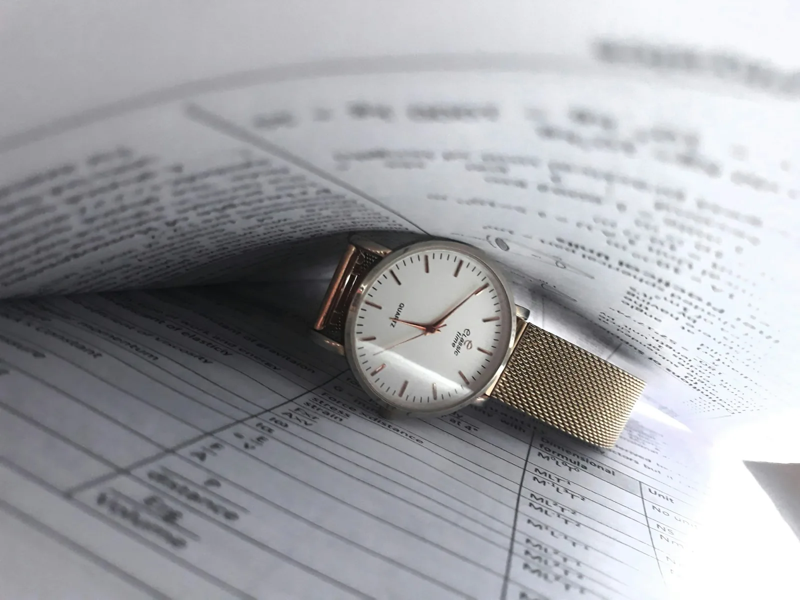 Paper documents and a service receipt laid out beside a wristwatch