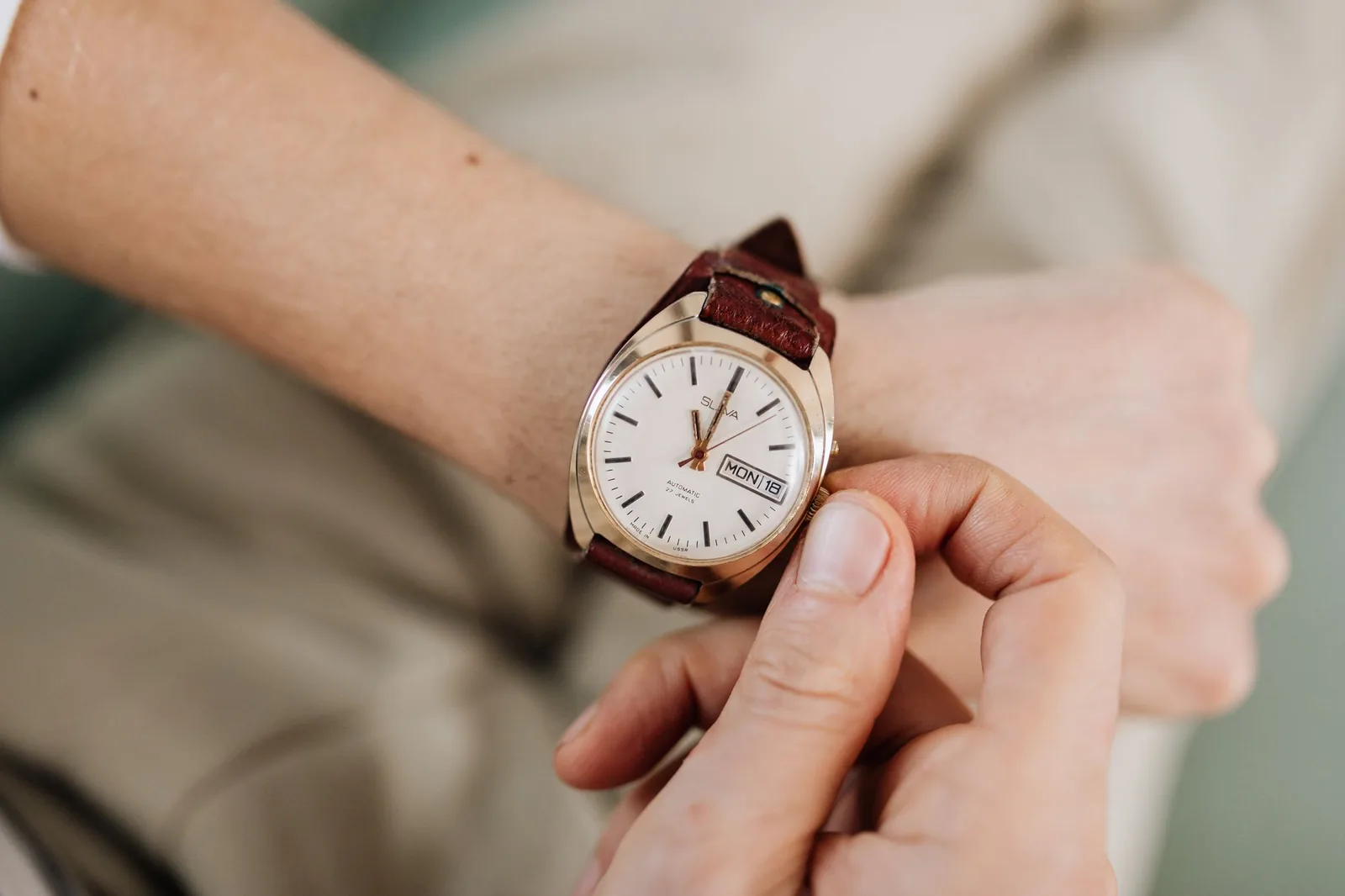 A wristwatch held in one hand and examined closely