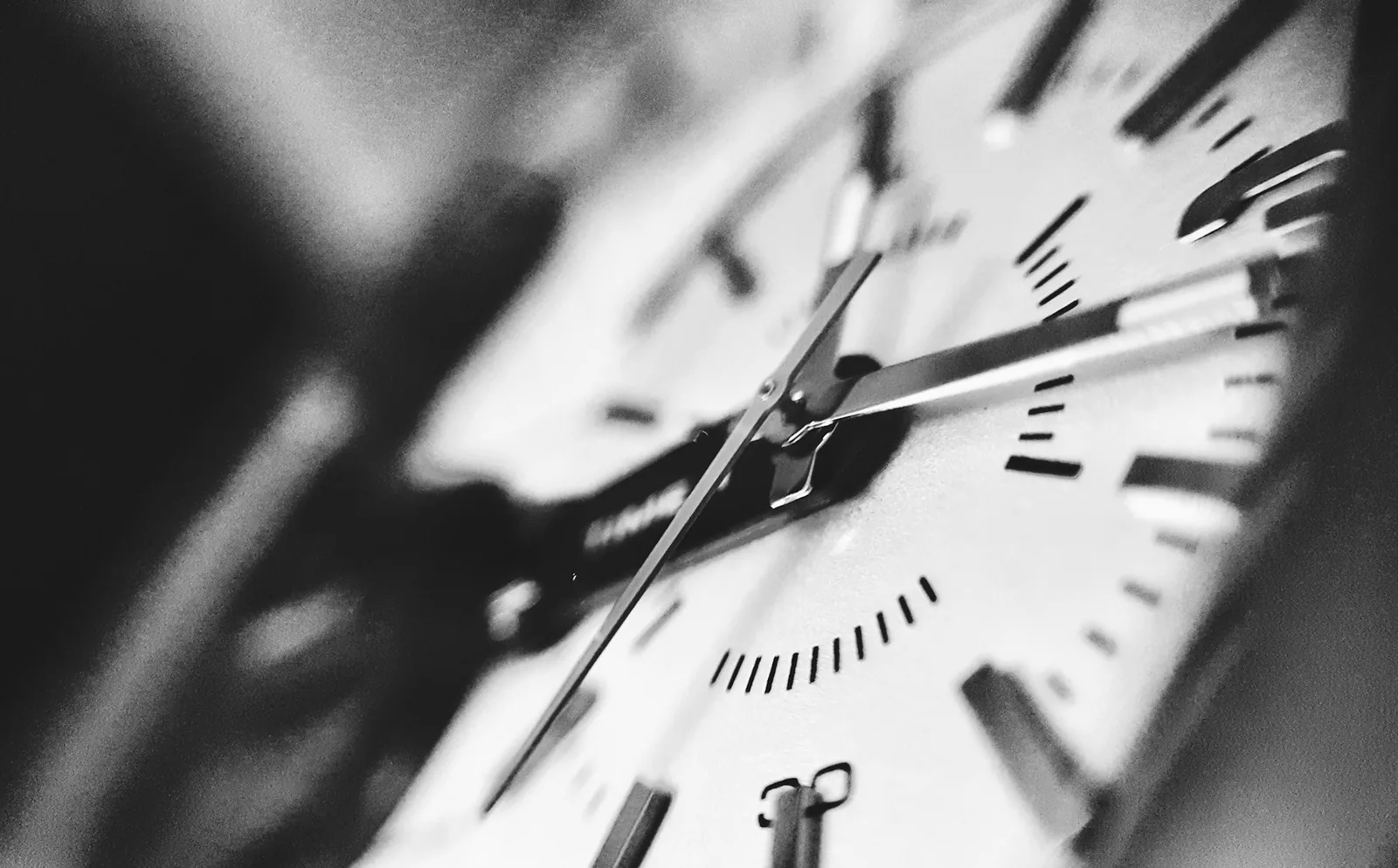 A wristwatch lying beside a clock face, both showing the time