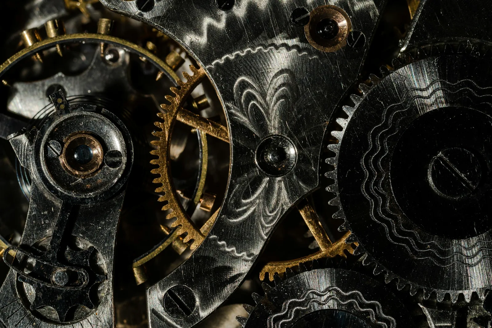A close macro view of brass gear wheels and jewelled bearings inside an open watch movement