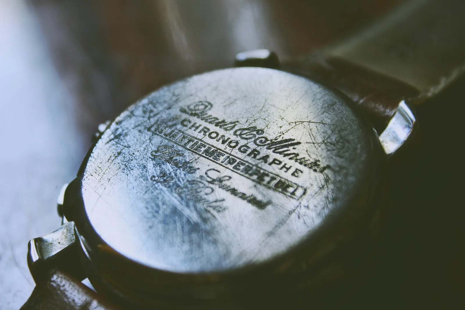 The engraved steel case back of an older wristwatch, showing serial markings and light scratches