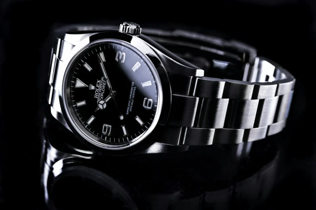 A wristwatch being wiped with a soft microfibre cloth on a clean work surface