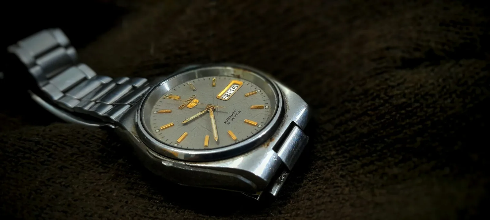 A wristwatch being wiped with a soft microfibre cloth on a clean work surface