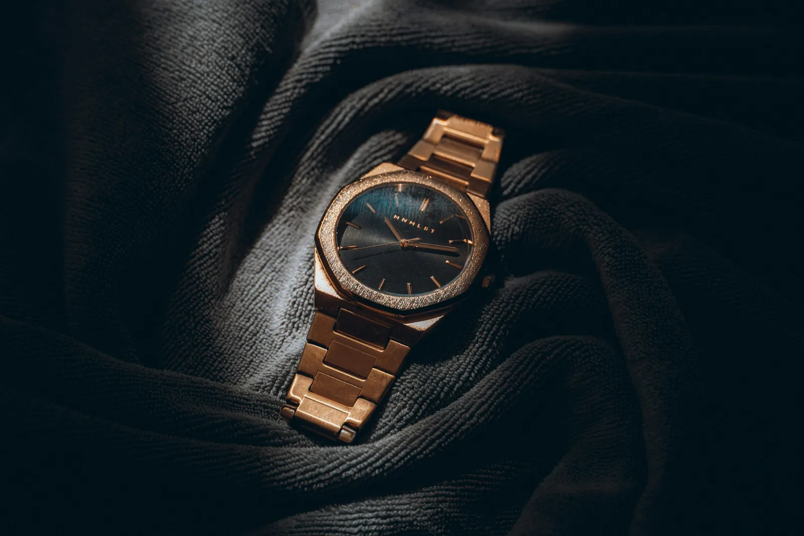 A steel wristwatch photographed against a plain dark background