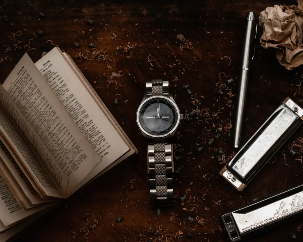 A wristwatch resting on a dark wooden surface in low light