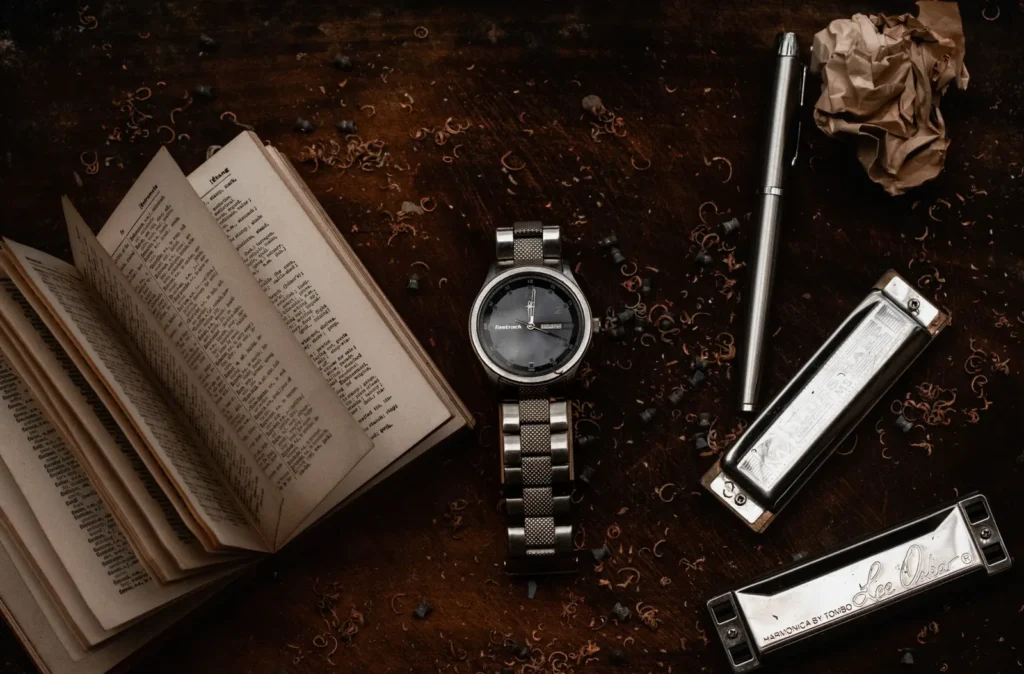 A wristwatch resting on a dark wooden surface in low light
