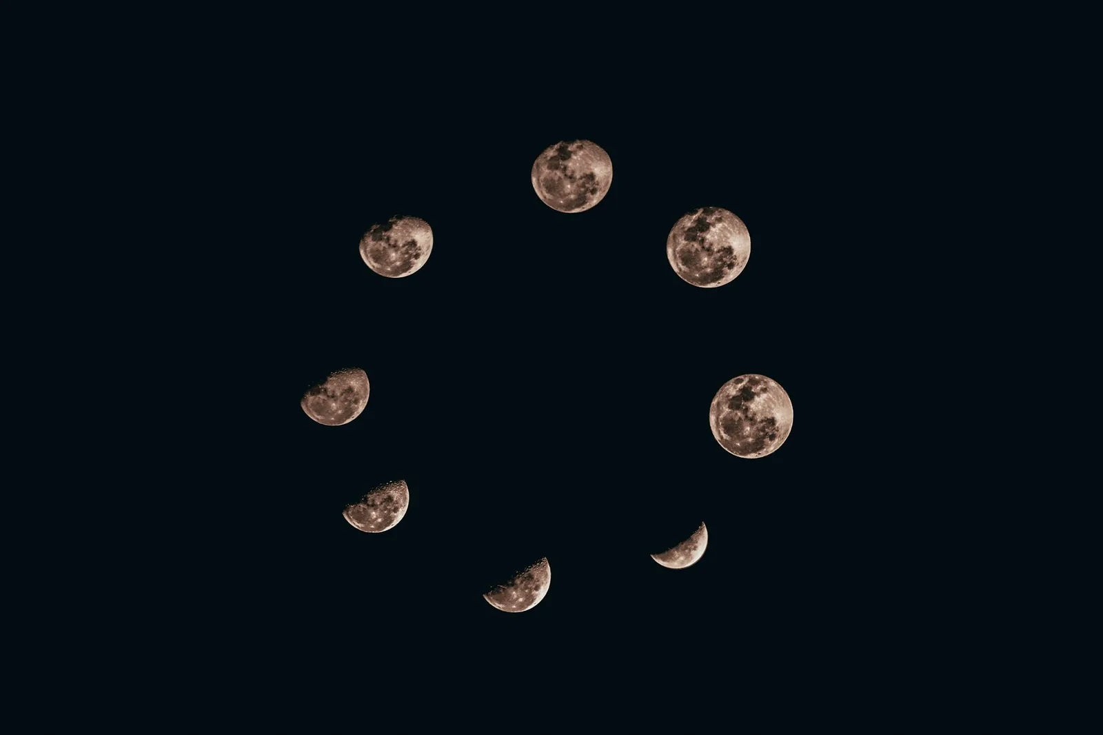 A watch dial with a moon phase aperture showing a crescent against a starred background