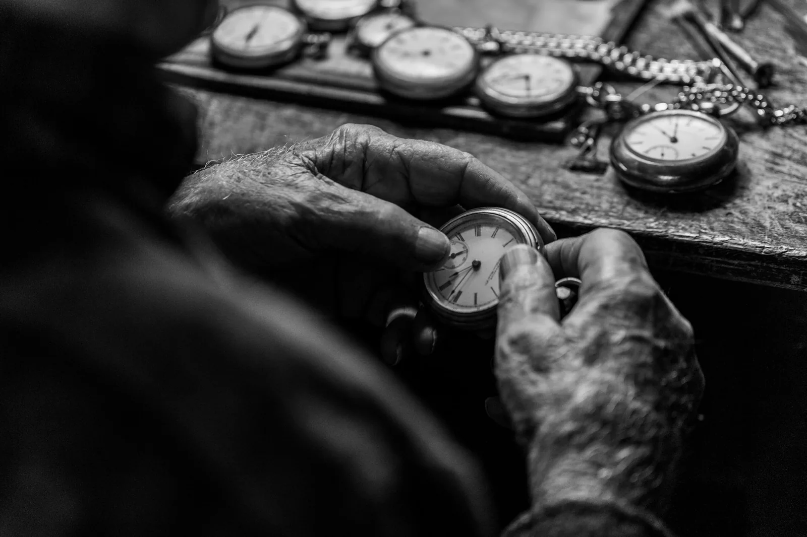 Fingers pulling out the crown of a wristwatch to set the time