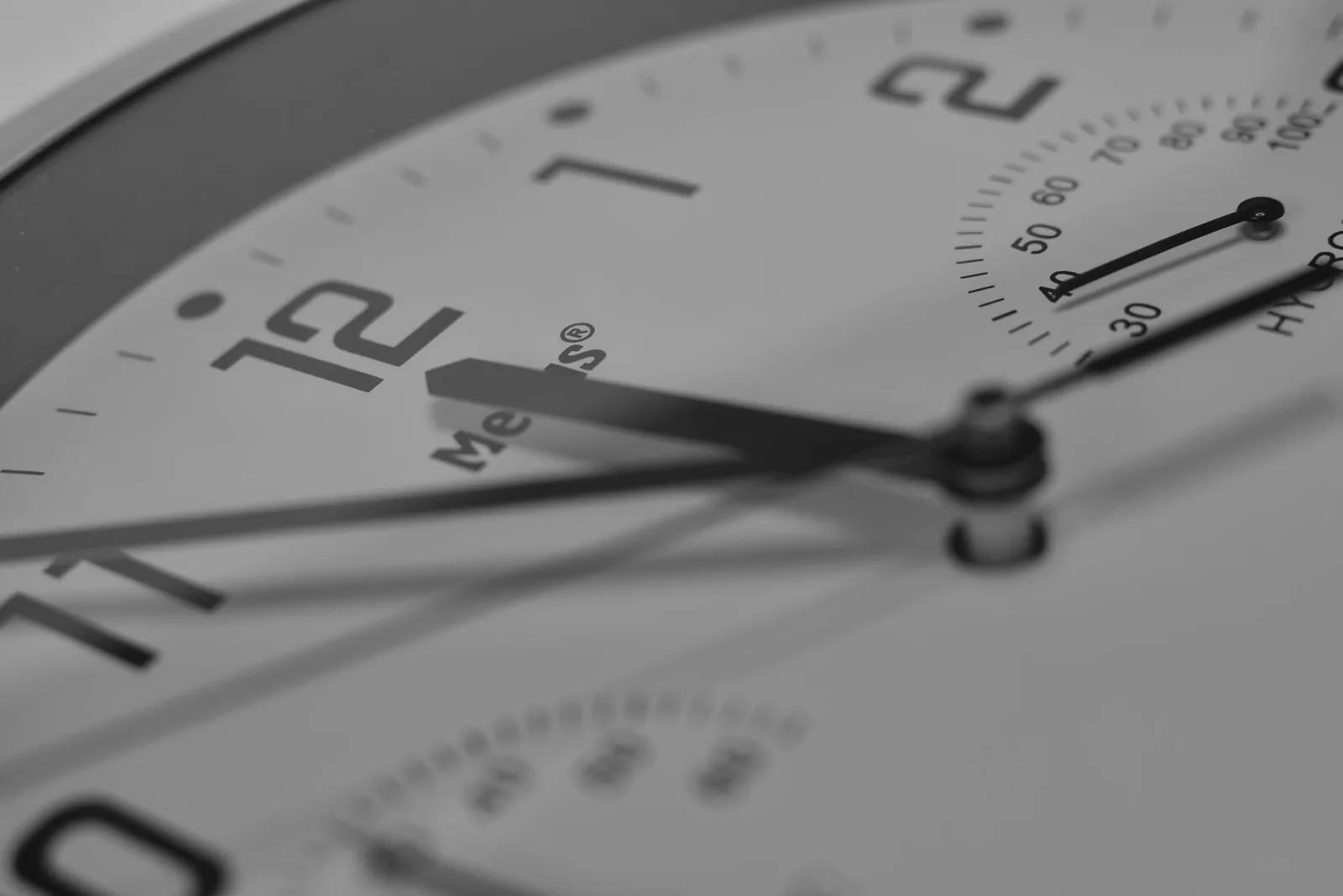 The hands and printed scale of a watch subdial photographed close up
