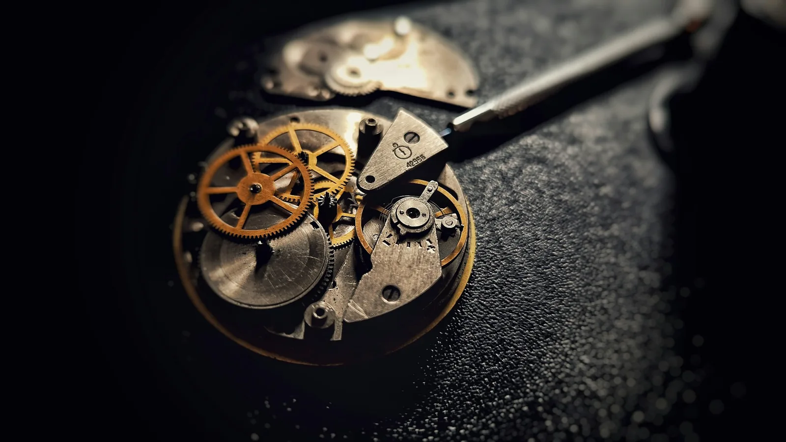 The oscillating weight of an automatic watch movement seen through a transparent case back