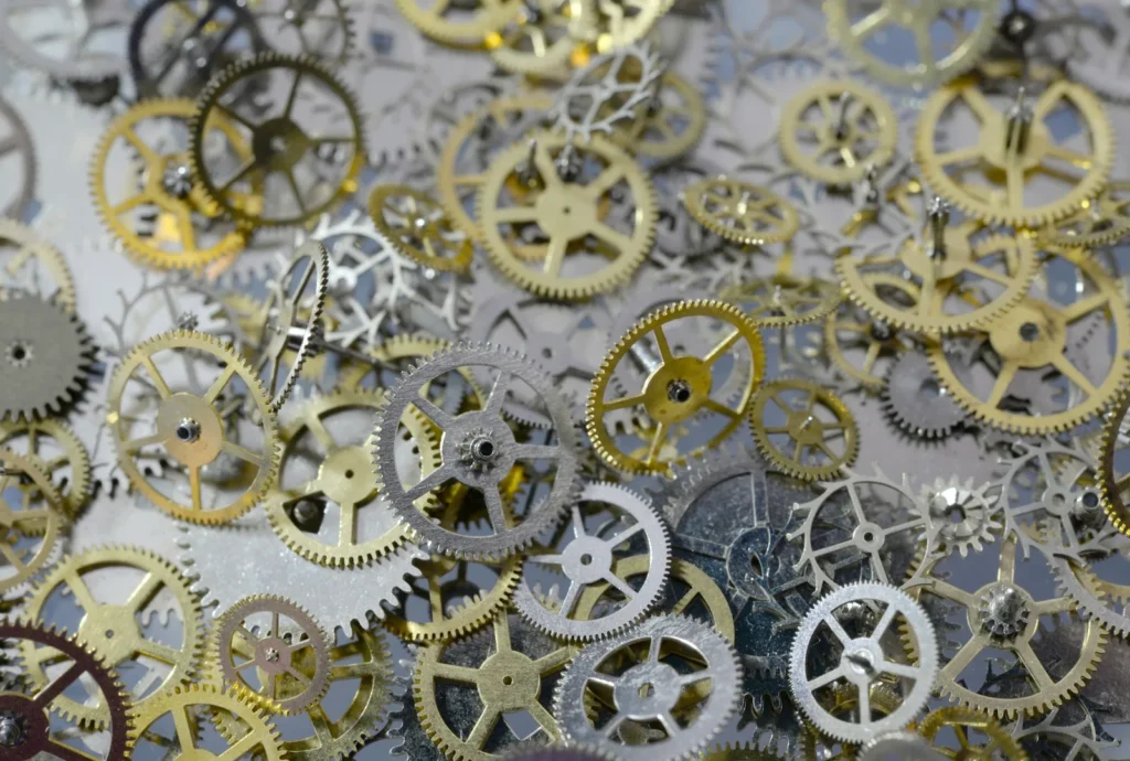 A macro photograph of an exposed watch movement showing the balance wheel and bridges