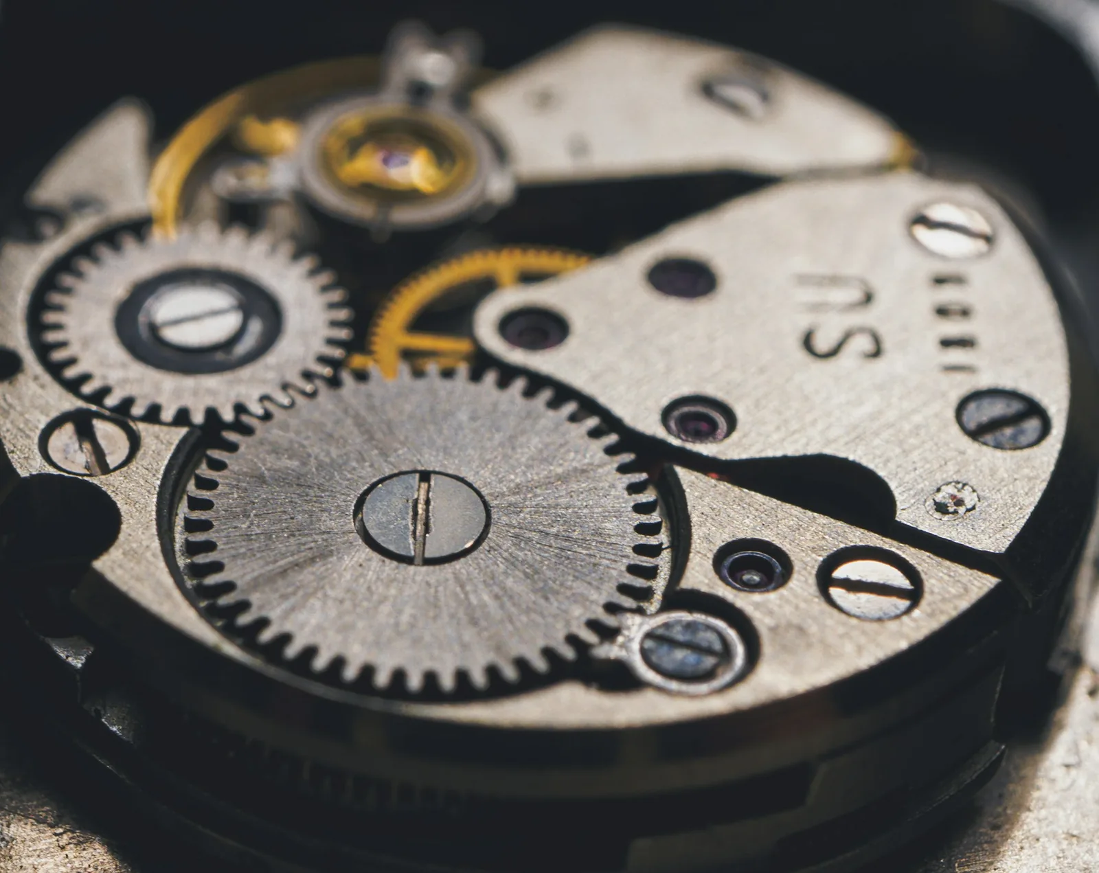 A jewelled bearing set into a metal watch bridge at high magnification