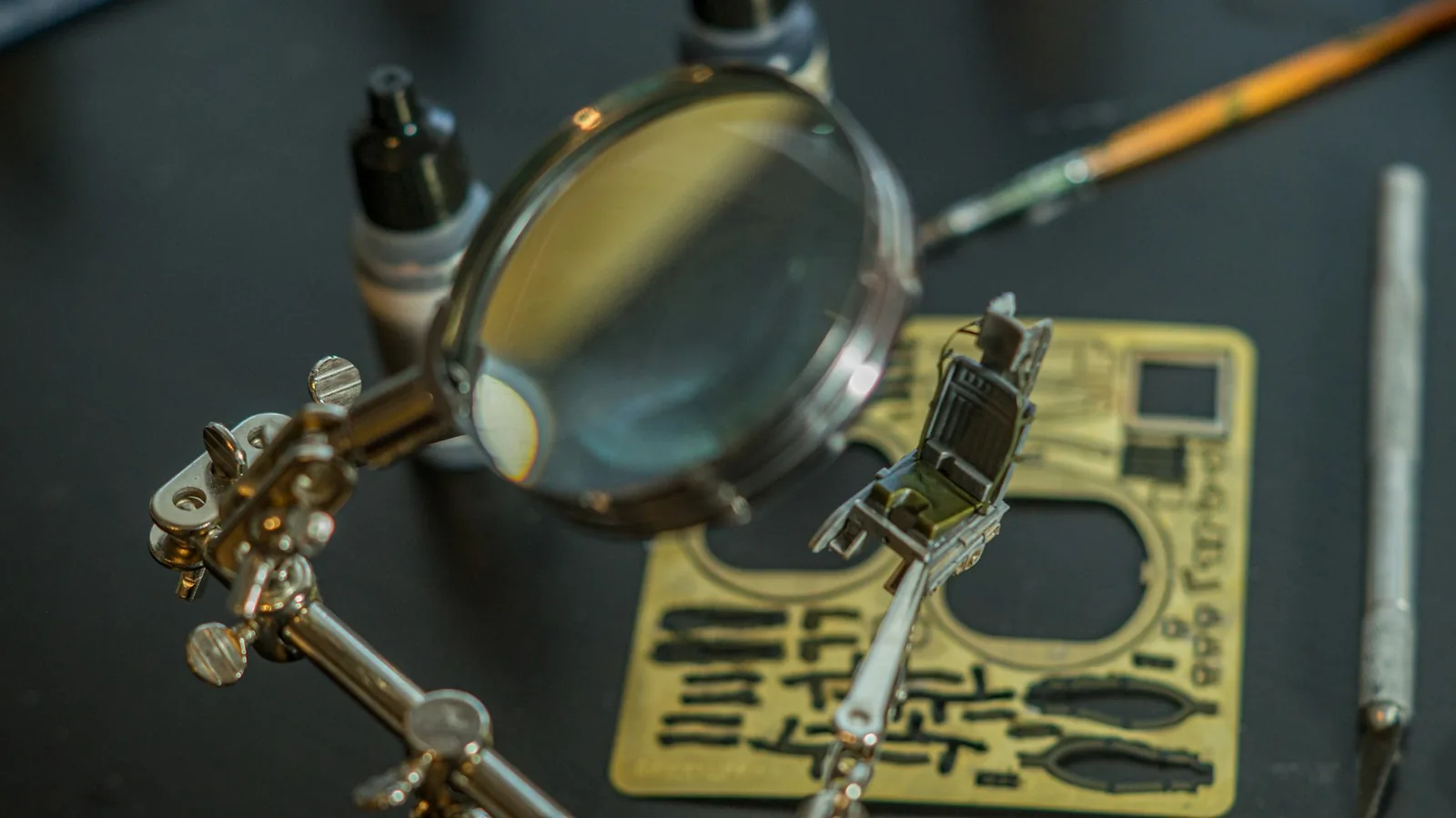 A watch on a repair bench beside a loupe and small tools