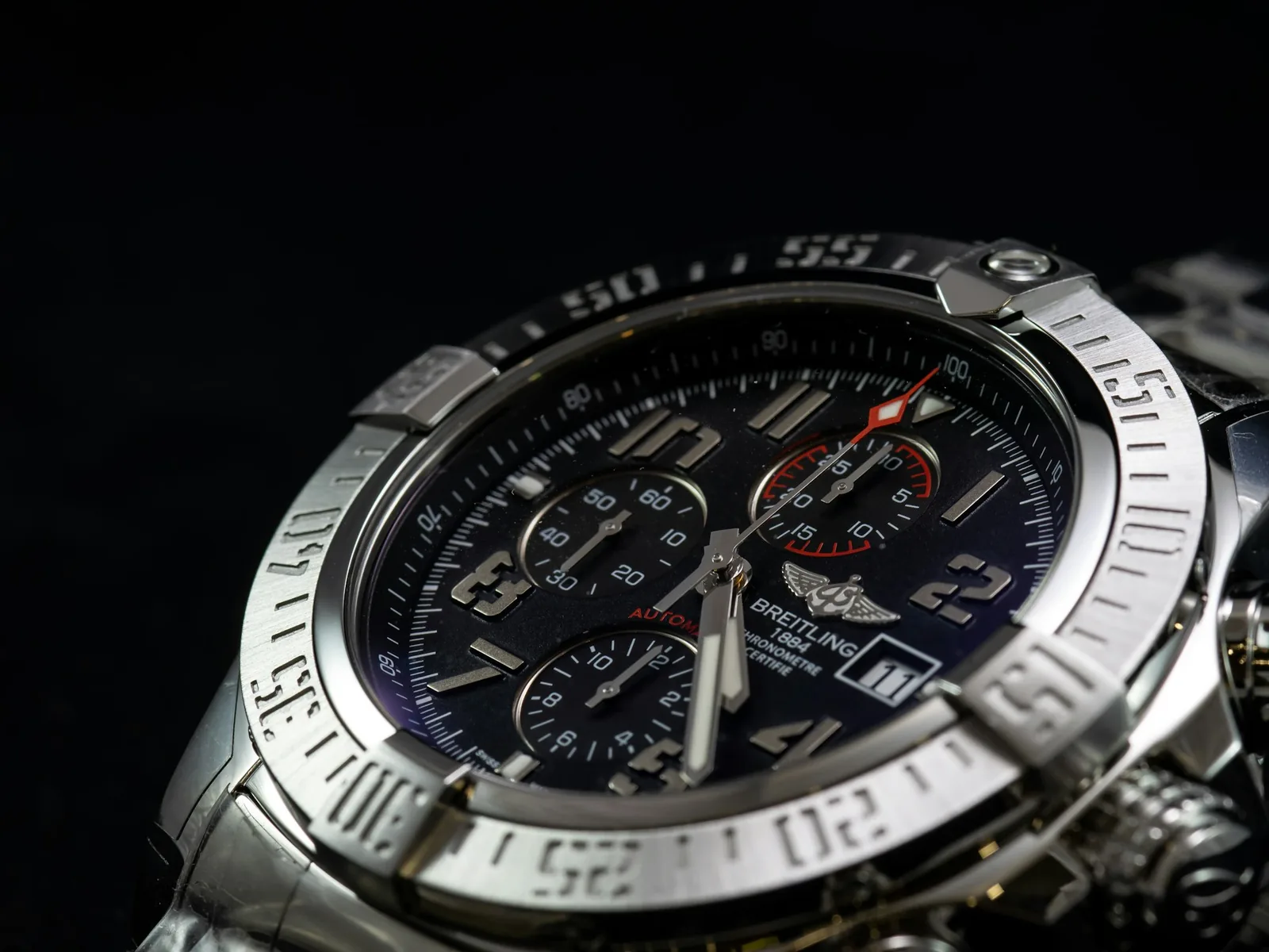 A polished steel watch case reflecting light along its edges