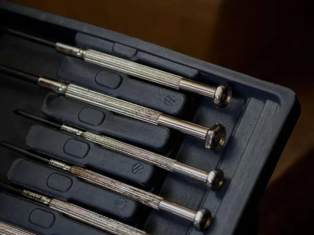 A row of watchmaker's screwdrivers laid out on a bench