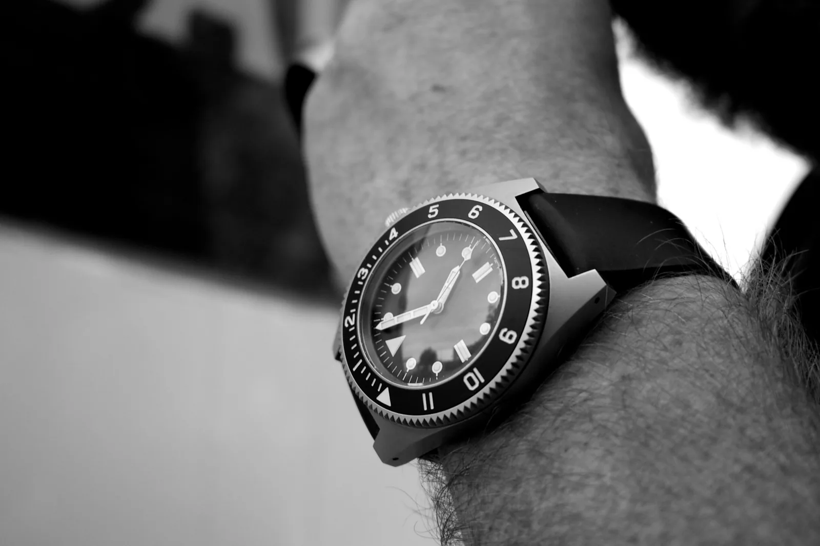 A dive watch photographed side on, showing the rotating bezel and the depth of the case