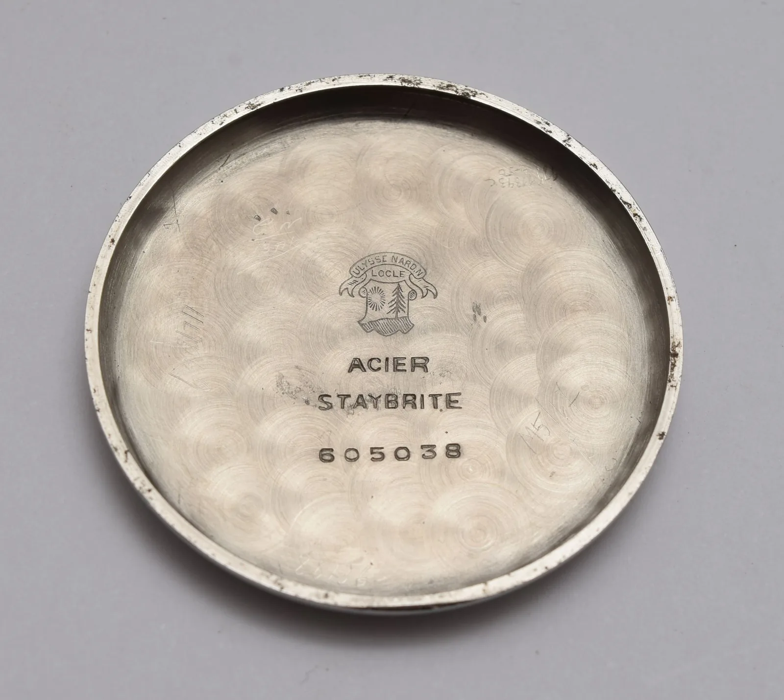 The plain steel case back of a wristwatch photographed close up