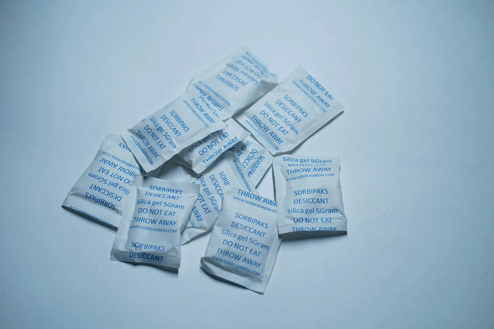 Small silica gel sachets sitting in a storage box
