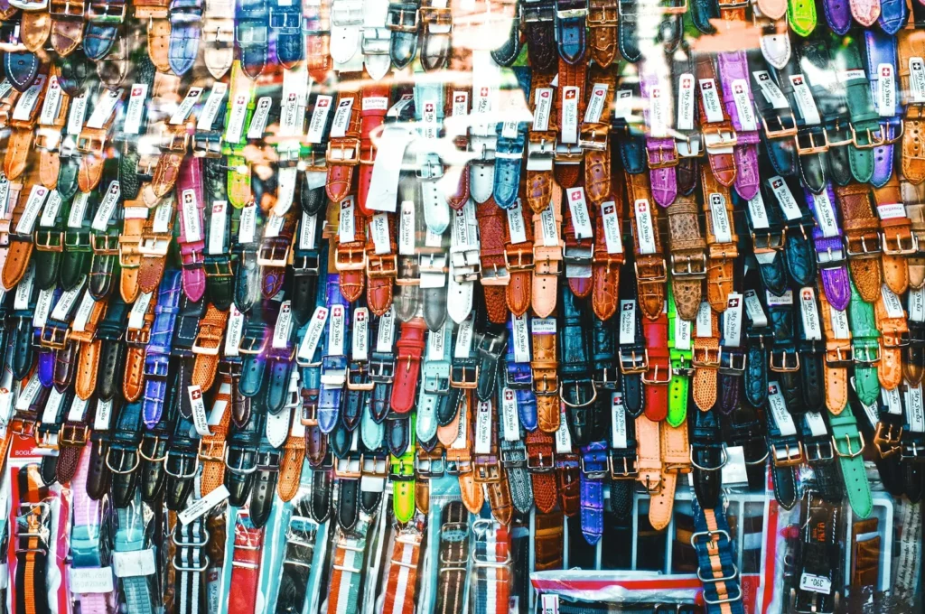 Several watch straps in leather, nylon and rubber laid out side by side on a plain surface