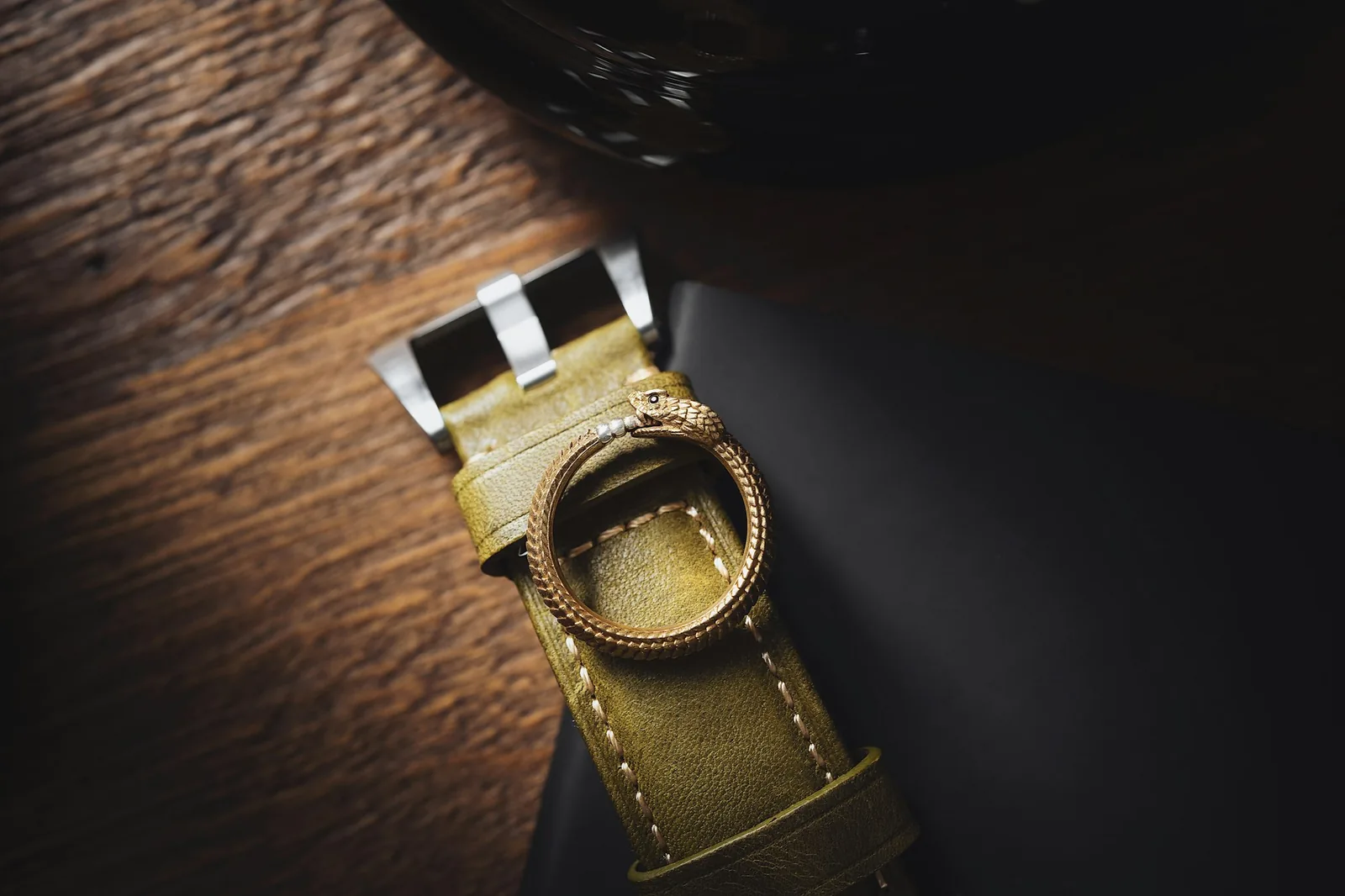 A worn brown leather watch strap photographed close up, showing creasing and stitching