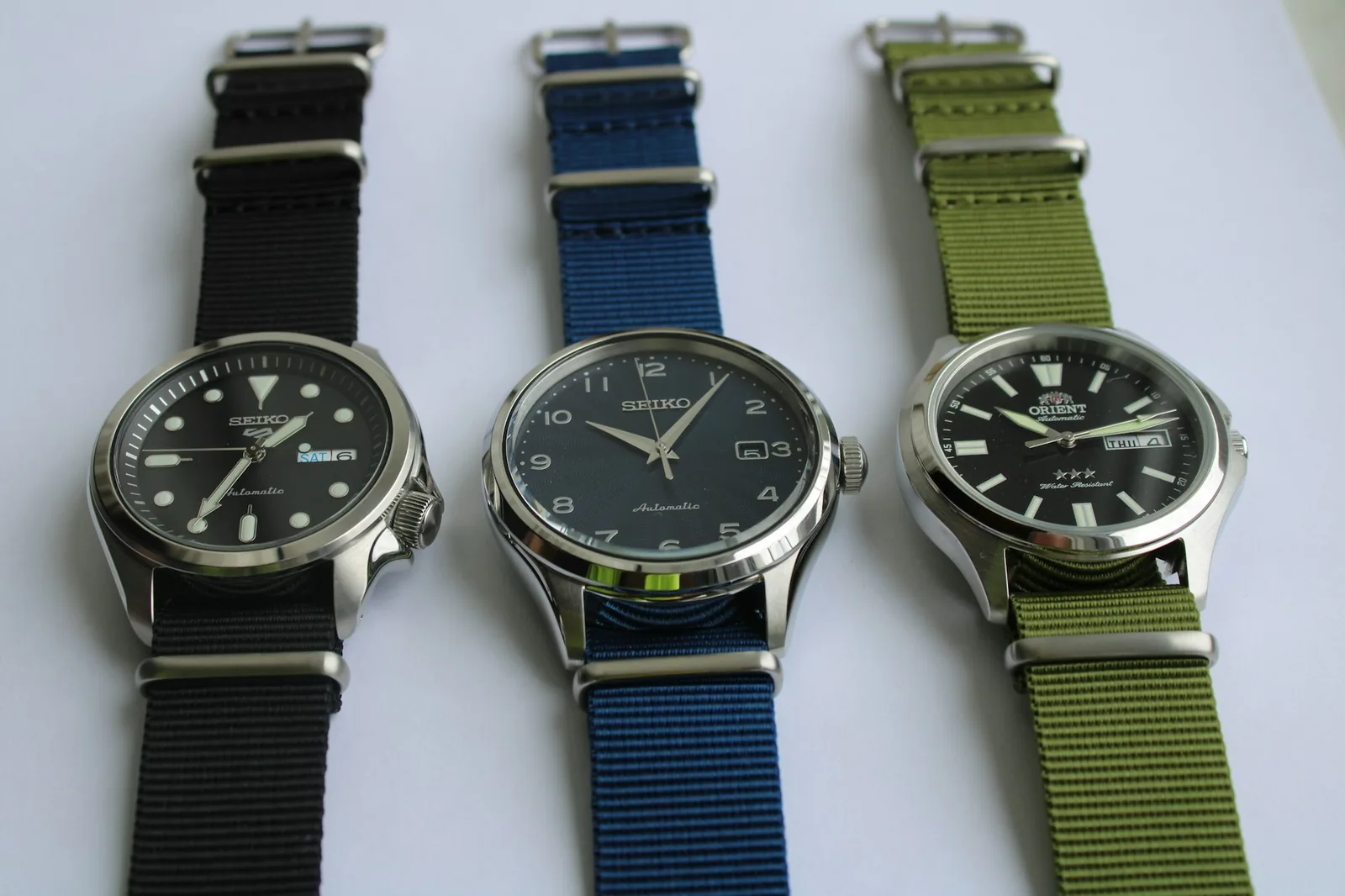 A striped nylon NATO strap threaded through the lugs of a watch, showing the keeper loops