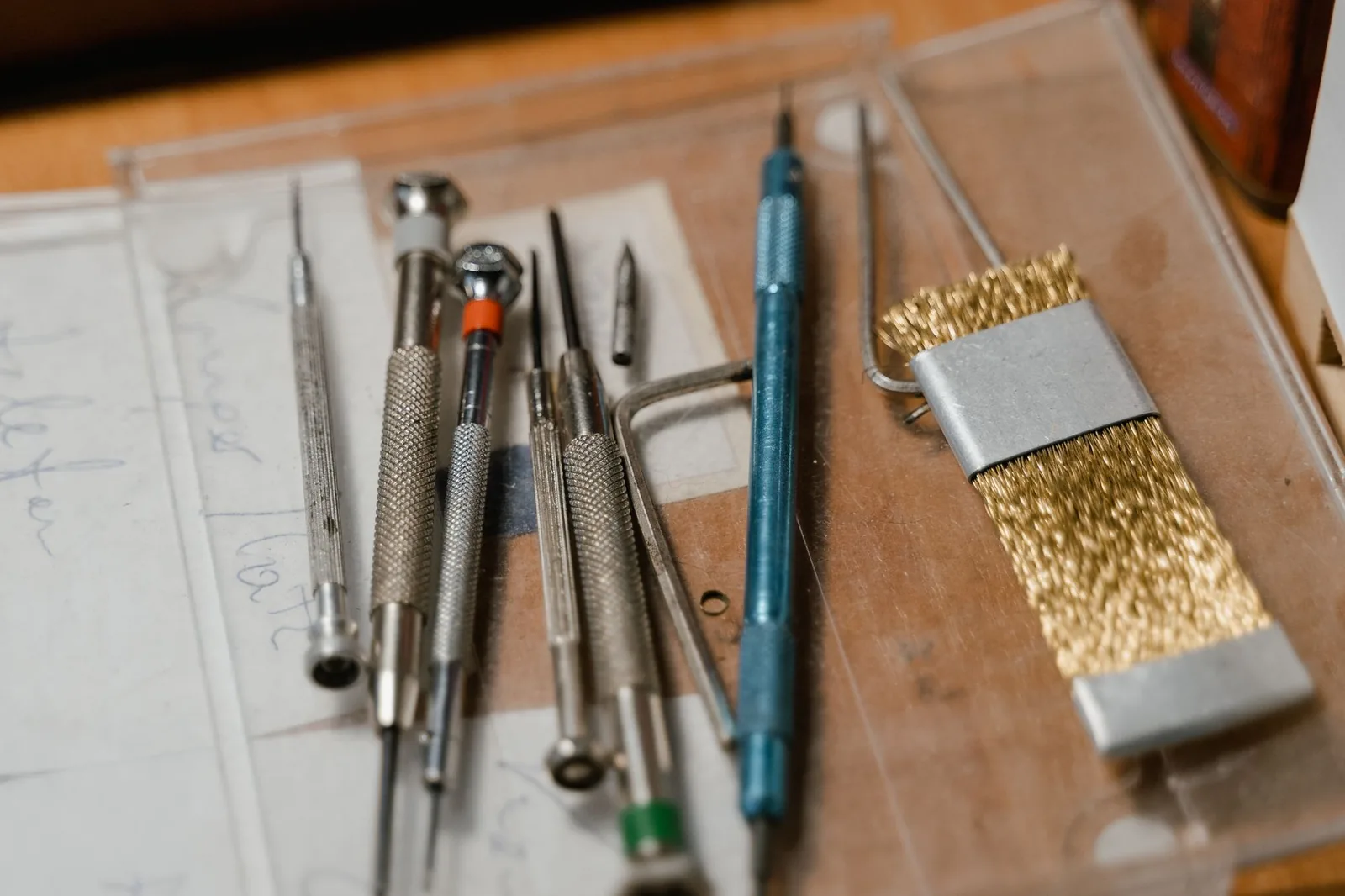 A spring bar tool positioned against the lug of a watch on a cloth-covered bench
