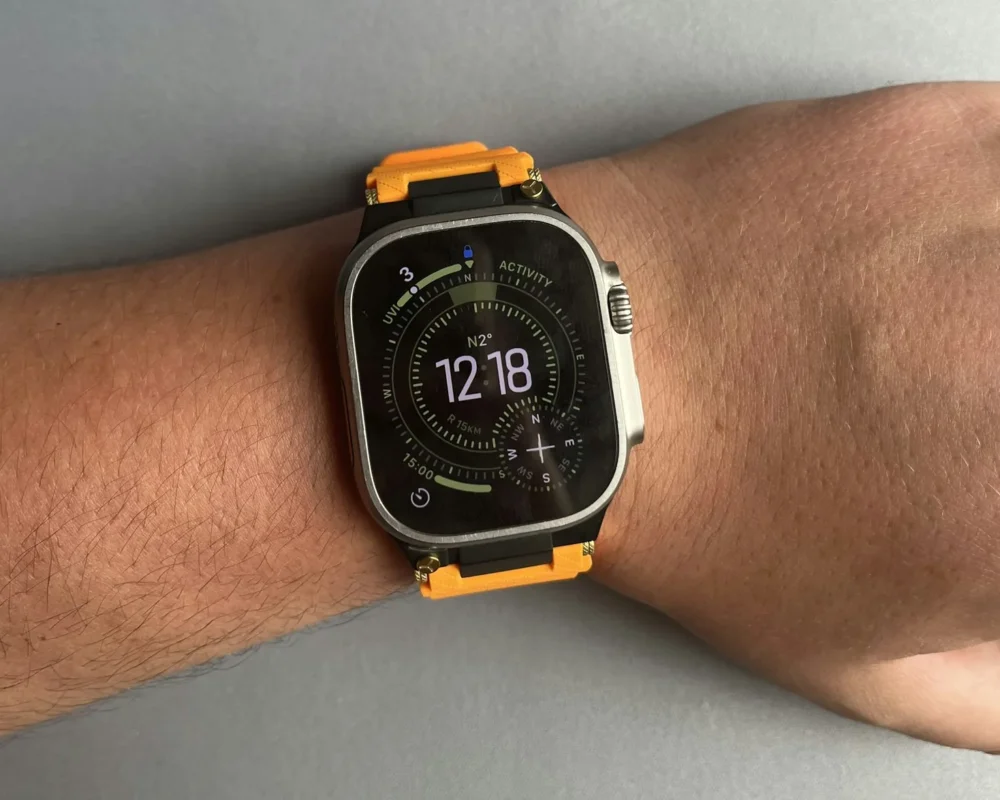 A robust wristwatch worn on a wrist outdoors against a blurred landscape