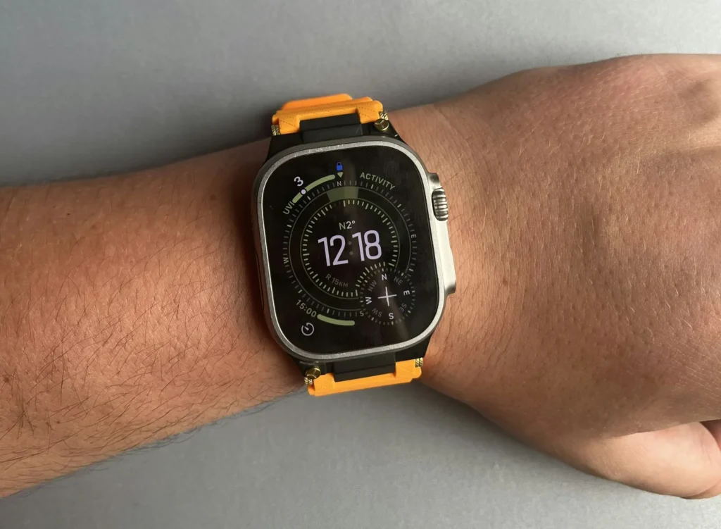 A robust wristwatch worn on a wrist outdoors against a blurred landscape